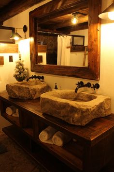 two stone sinks sit under a large mirror