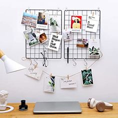 a laptop computer sitting on top of a desk next to a wire rack with pictures