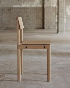 a wooden chair sitting on top of a cement floor