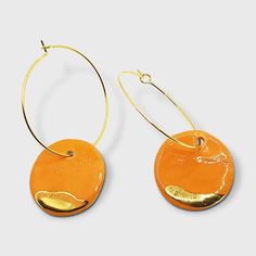 Orange and gold clay hoops earrings Iris. These clay earrings are simply gorgeous. The orange shade is wonderfull and the contrast with the real gold too. Orange is such a happy color and brighten your day and your outfit. For a stylish look, do not hesitate to gift yourself or someone you love these earrings. They come in a beautiful pink gift box. The style of the earrings is minimalist with geometric forms. Those earrings are very very light, few grams. All my earrings are handmade made by me in my studio. A layer of handpainted gold is applied with a brush. Here is an overview of my process, first the pendant is made using stoneware, which is a high temperature clay like porcelain, so it is solid. Once it is dry, I put the pendant in the kiln for 8 hours, then I glaze the pendant and p Orange Clay Earrings, Pink Gift Box, Orange And Gold, Hoops Earrings, Provence France, Pink Gifts, Happy Colors, Shades Of Orange, Etsy Jewelry