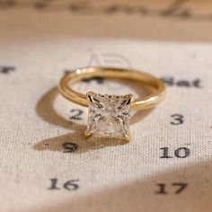 a gold ring with a princess cut diamond