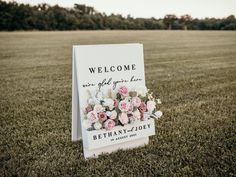 a welcome sign sitting in the middle of a field