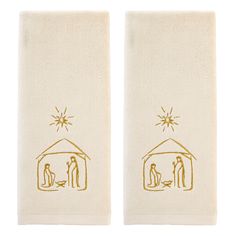 two white towels with gold hand drawn images of people in a barn and the words, we are family