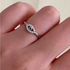 a woman's hand with a diamond and blue eye ring on top of it