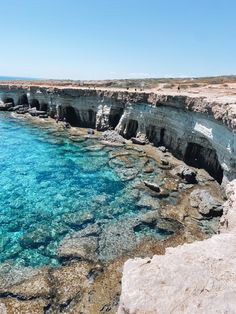 the water is crystal blue and clear at this rocky shore line near an ocean cliff