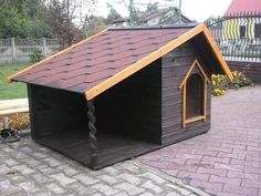 a dog house with a red roof and brown shingles