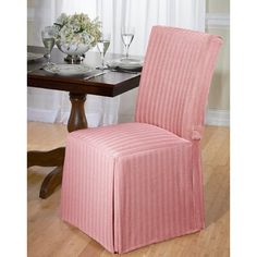 a pink chair sitting in front of a wooden table