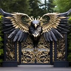 an intricately designed gate with a large bird on it's back and wings spread out