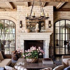 a living room filled with furniture and a fire place in front of a stone fireplace