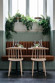 an instagram page with two tables and chairs in front of green walls, plants on the wall