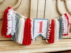 a red, white and blue tasseled garland with the number one on it