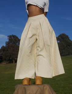 .. A forever wardrobe staple, the Khadijah Pant is a mid-high waisted wide leg pant. With double pleating cascading down the front of each pant leg, this voluminous detail takes on the illusion of a maxi skirt. The smooth waistband on the front fades into an elasticated one on the back. This detail is intended for a comfortable wear, while cinching your waist to ensure the proper fit. .. Mid-high waisted, wide leg pant .. Double pleating on each pant leg .. 2" smooth waistband on front, elastica Chic Pleated Relaxed Fit Wide Leg Pants, Chic Pleated Wide Leg Pants With Relaxed Fit, Chic Wide Leg Pleated Pants With Relaxed Fit, Chic Pleated Wide Leg Pants, Chic Cotton Pleated Wide Leg Pants, Chic Pleated Cotton Wide Leg Pants, Pleated Wide Leg Pants For Summer, Chic Pleated Wide Leg Bottoms, Pleated Wide-leg Pants