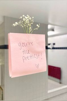 a post it note attached to a glass door with flowers in the middle and writing you're the prettiest