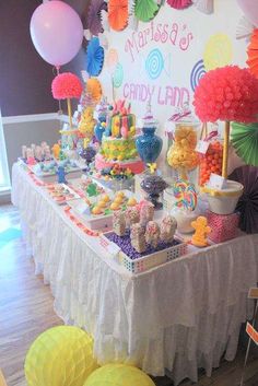 a table topped with lots of candy and balloons