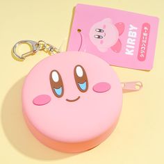 a pink key chain with a smiley face on it and a card attached to it