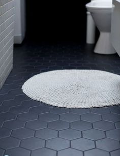 a white toilet sitting next to a bath tub in a bathroom on top of a tiled floor