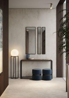 a modern bathroom with two stools and a mirror on the wall above it, next to a plant