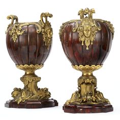 two ornately decorated vases sitting on top of each other in front of a white background