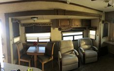 the inside of an rv with chairs and tables