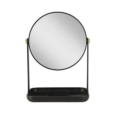 a round mirror sitting on top of a black stand