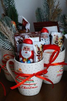 two mugs filled with candy and christmas decorations