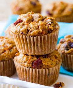 three muffins sitting on top of a white napkin next to each other with crumbled toppings