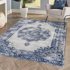 a blue and white area rug with an ornate design on the center, sitting in a living room