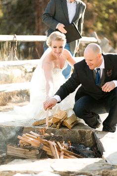 the bride and groom are preparing to roasting marshmallows over an open fire