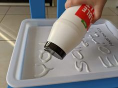 a person is pouring something into a plastic container