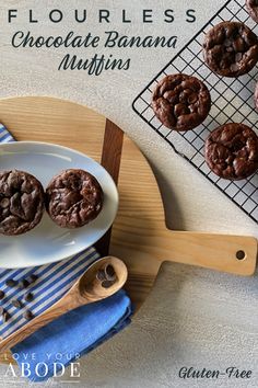 three chocolate banana muffins on a plate next to a cooling rack and blue towel