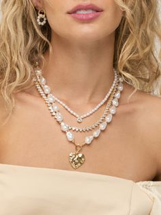 Fall in love with this Still Standing Pearl Heart Necklace! This gold heart necklace is adorned with delicate acrylic pearl strands, making it the perfect accessory for any outfit. Stay stylish and stand out from the crowd with this unique piece. Imitation Pearl Beads 48 cm long 18k Gold Plated Over Brass Extendable Lobster Clasp Gold Heart-shaped Pearl Beaded Necklaces, Heart-shaped Pearl Necklace With Heart Beads, Trendy Heart-shaped Pearl Chain Necklace, Elegant Heart-shaped Pearl Chain Necklace, Heart-shaped Pearl Chain Necklace For Valentine's Day, Bow Necklace, Mini Bows, Gold Heart Necklace, Still Standing