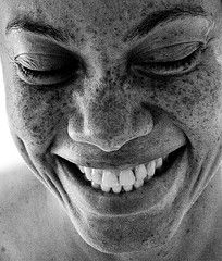 a black and white photo of a man with freckles on his face smiling