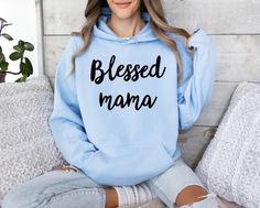 This Blessed Mama, Blessed Mom Shirt is perfect for any mom who feels blessed with her role as a mother. This design will be printed using the DTG method for a high-quality, vibrant finish. The unisex heavy blend hooded sweatshirt is made from a thick blend of cotton and polyester, making it soft, warm, and comfortable to wear on cold days. It features a spacious kangaroo pocket on the front for practicality and a hood with a matching drawstring for added style. Made from 50% cotton and 50% poly Blessed Mama Shirt, Mom Wardrobe, Blessed Mama, Mama Shirt, Mom Shirt, A Mother, Cold Day, Mom Shirts, Kangaroo Pocket