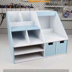 a blue and white shelf with two bins on it's sides in a craft room