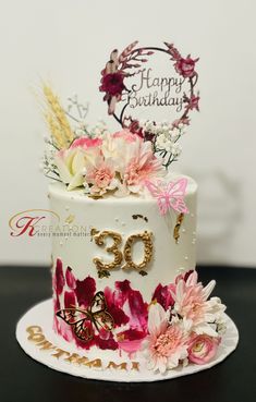 a birthday cake decorated with flowers and butterflies