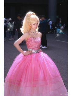 a woman in a pink dress posing for the camera