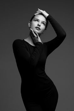 black and white photo of a woman in tight clothing with her hands on her head