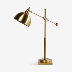 a gold lamp on a white background with the light turned off and one arm extended