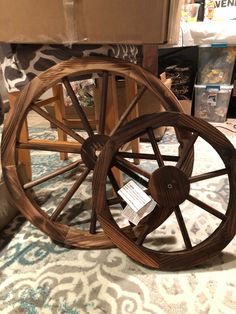 an old wooden wagon wheel is on the floor next to some boxes and other items