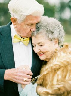 an older couple embracing each other in front of trees