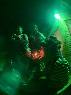 a group of people sitting around each other in the dark with one person holding a lit candle