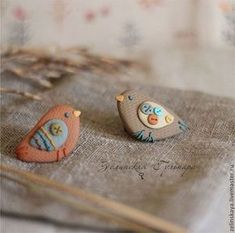 two small birds sitting on top of a piece of fabric