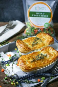 two pies sitting on top of a table next to a bag of king's veggies