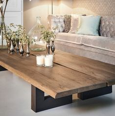 a wooden table with candles on it in front of a couch