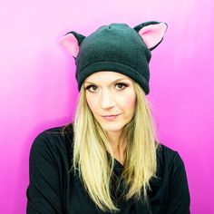 a woman with long blonde hair wearing a black hat and cat ears on her head