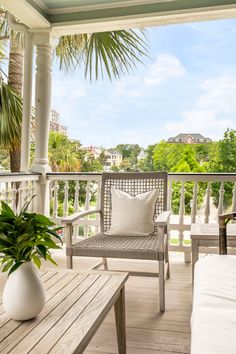 a porch with white furniture and palm trees