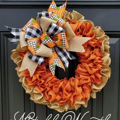 an orange and black burluck wreath on the front door