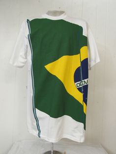 "Vintage 1980s 90s color block t-shirt. Large hip hop design made by Tropicante. Made of white poly/cotton. Features large flag. Letters stager, but I think it says \"ORDEM E PROGRESSO\". Made by Tropicante. Size XL. Actual measurements are: 46\" around the chest 46\" around the waist 23\" shoulder seam to shoulder seam 33\" overall length In unused condition, new old stock. Print is overlapping at \"ORDEM\"." Hip Hop Design, Color Block Shirts, Hip Hop Shirts, 90s Colors, Vintage Tshirts, Shirt Color, Vintage Clothing, Color Block, Vintage Outfits