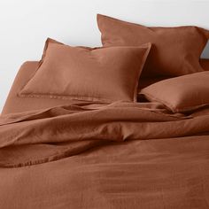 a bed with brown sheets and pillows on it