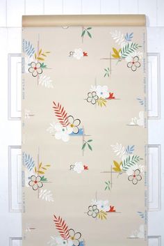 an image of a wall hanging on the side of a door with flowers and leaves painted on it